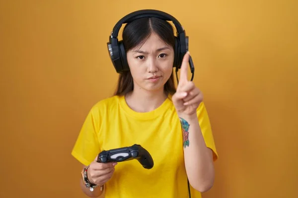中国年轻女子玩电子游戏时拿着控制器 手指头尖着 满脸怒容 没有任何动作 — 图库照片