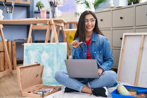 Young Teenager Girl Sitting Art Studio Using Laptop Pointing Thumb — Stockfoto
