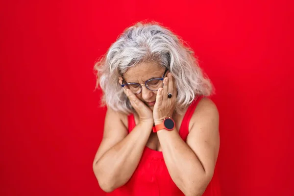 Kırmızı Arka Planda Duran Gri Saçlı Orta Yaşlı Bir Kadın — Stok fotoğraf