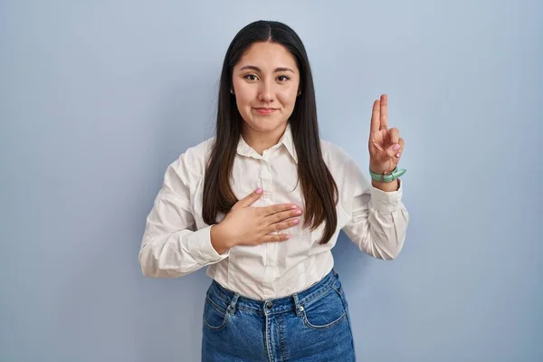 Young Latin Woman Standing Blue Background Smiling Swearing Hand Chest — ストック写真