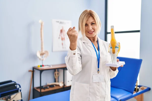 Middle Age Blonde Traumatologist Woman Holding Anatomical Model Knee Joint — Fotografia de Stock