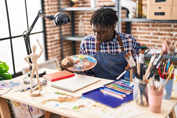 非洲裔美国人艺术家在艺术工作室里用怀疑的表情看笔记本 — 图库照片