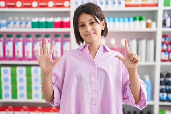 Mladá Dívka Lékárně Drogerie Ukazuje Ukazuje Prsty Číslo Sedm Zároveň — Stock fotografie
