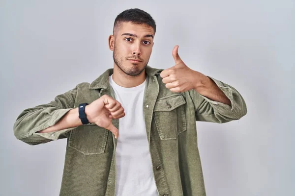 Young Hispanic Man Standing Isolated Background Doing Thumbs Disagreement Agreement — Stockfoto