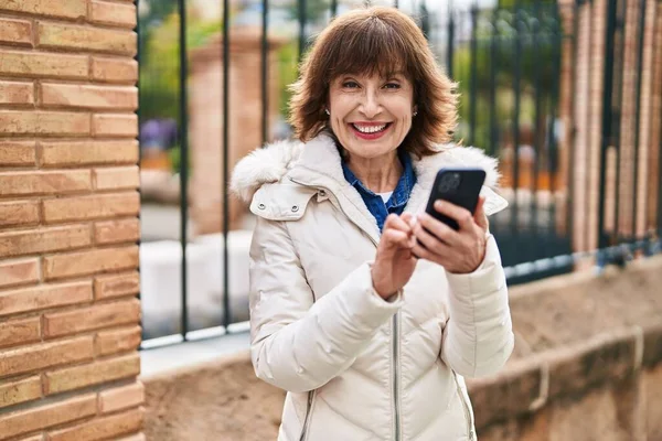 Sokakta Akıllı Telefon Kullanan Orta Yaşlı Bir Kadın Gülümsüyor — Stok fotoğraf