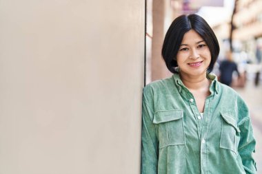 Young chinese woman smiling confident standing at street