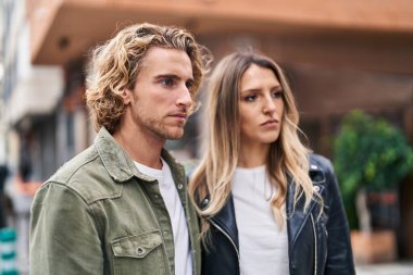 Man and woman couple standing together with relaxed expression at street