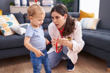 Anne ve oğul doktor evdeki çocuğu muayene ediyor.