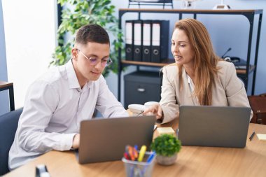 Man and woman business workers using laptop working at office