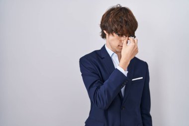 İspanyol iş adamı gözlüklü genç adam yorgun burnu ve gözleri ovuşturup yorgun ve baş ağrısı çekiyor. Stres ve hüsran kavramı. 