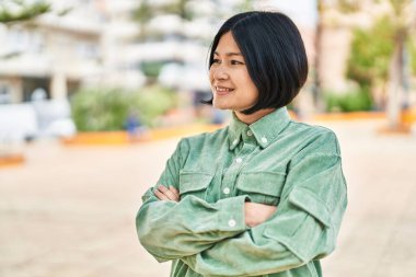 Young chinese woman smiling confident standing with arms crossed gesture at park
