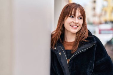 Sokakta kendinden emin gülümseyen genç bir kadın