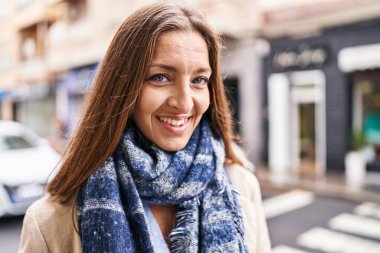 Sokakta kendinden emin gülümseyen genç bir kadın