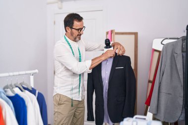 Terzi dükkanında kendine güvenen orta yaşlı bir terzi.