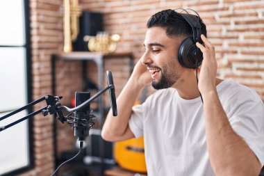 Genç Arap sanatçı müzik stüdyosunda şarkı söylüyor.