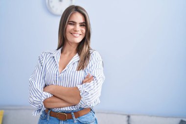 Young woman smiling confident standing with arms crossed gesture at home