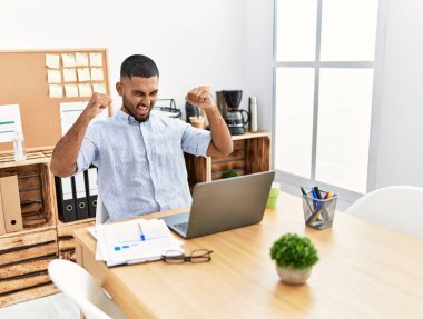 Genç Arap adam ofiste neşeli çalışıyor.