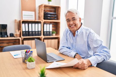 Ofiste çalışan orta yaşlı erkek ve kadın işçiler.