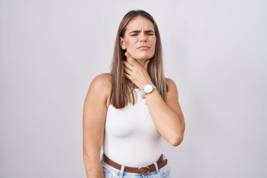 Hispanic young woman standing over white background touching painful neck, sore throat for flu, clod and infection 