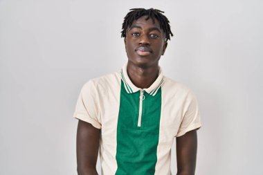 Münzevi arka planda duran Afrikalı adam yüzünde ciddi bir ifadeyle rahatladı. Basit ve doğal bir şekilde kameraya bakıyorsun.. 