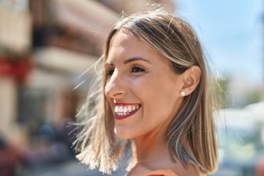 Young beautiful hispanic woman smiling confident looking to the side at street