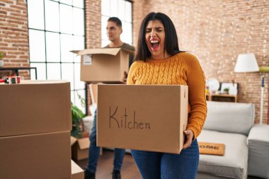 Karton kutularla dolu yeni bir eve taşınan genç çift kızgın ve öfkeli çığlıklar atıyor. Öfkeyle bağırıyorlar. öfke ve agresif konsept. 