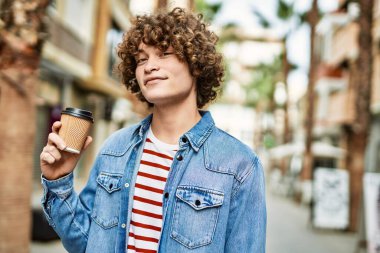 Genç İspanyol adam şehirde bir fincan kahve içiyor.