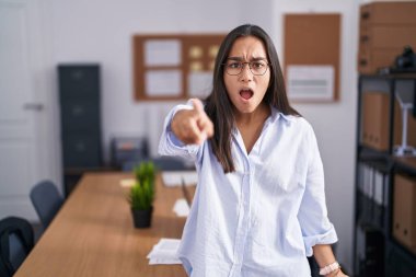 Ofisteki genç İspanyol kadın kameraya kızgın ve sinirli bir şekilde seni işaret ediyor. 