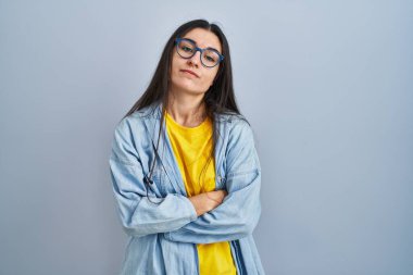 Mavi arka planda duran genç İspanyol kadın uykulu ve yorgun görünüyor, yorgunluktan yorgun ve akşamdan kalma, sabahları tembel gözler.. 