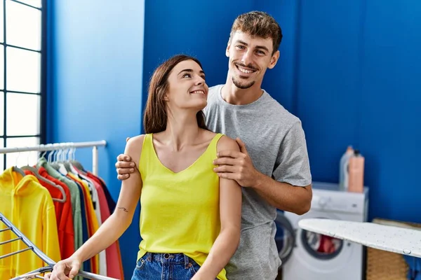 男と女のカップル抱擁お互いにハング服に服で洗濯室 — ストック写真