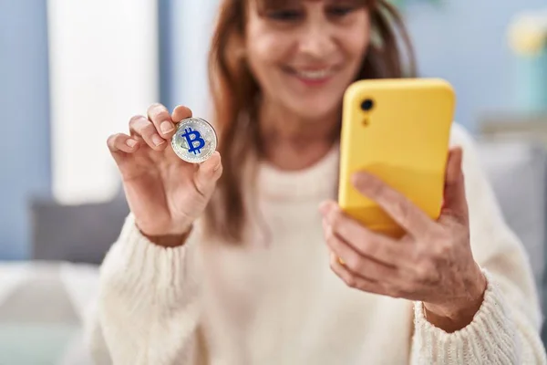 Middle Age Woman Using Smartphone Holding Bitcoin Home — Stock Photo, Image