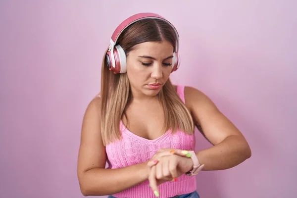 Young Blonde Woman Listening Music Using Headphones Checking Time Wrist — Fotografia de Stock