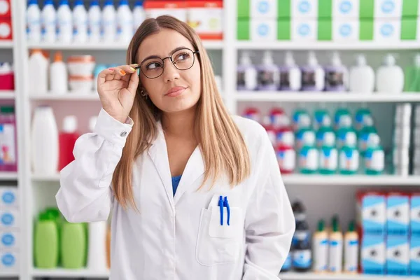 年轻美丽的惊慌失措的女药剂师自信地站在药店 — 图库照片