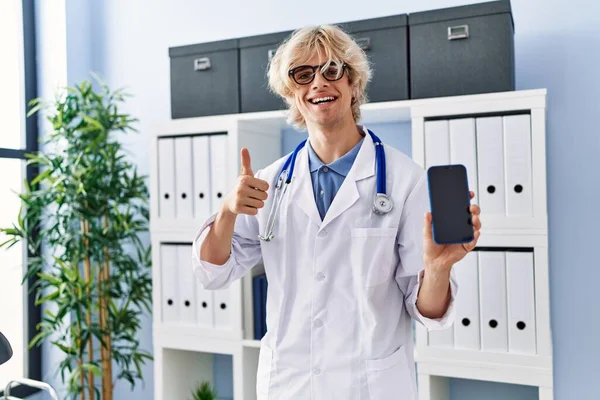Young Doctor Man Showing Smartphone Screen Smiling Happy Positive Thumb — Stockfoto