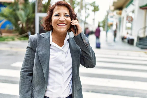 中世のラテン語のビジネス女性は 市内のスマートフォンで幸せな話を笑っています — ストック写真