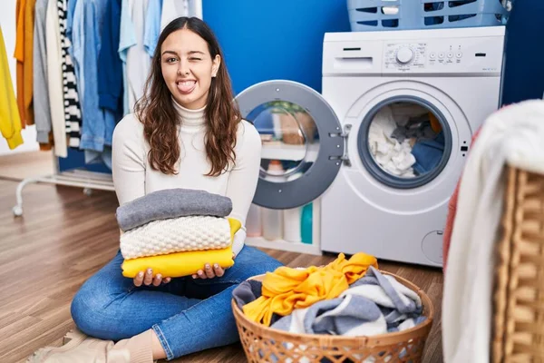 Young Hispanic Woman Holding Clean Laundry Sticking Tongue Out Happy — Photo