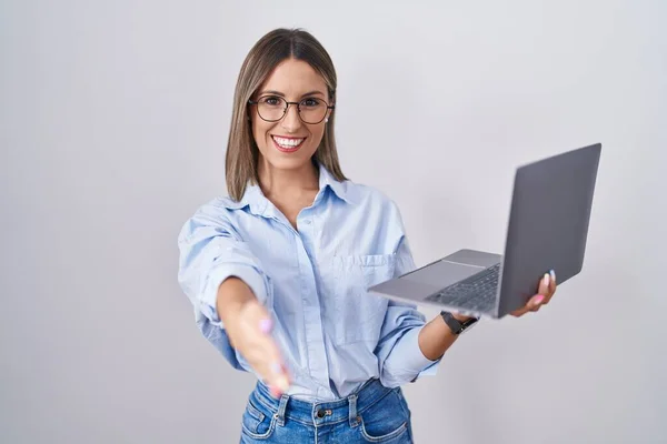 使用笔记本电脑工作的年轻女性友好地微笑着握手致意和欢迎 成功的商业 — 图库照片