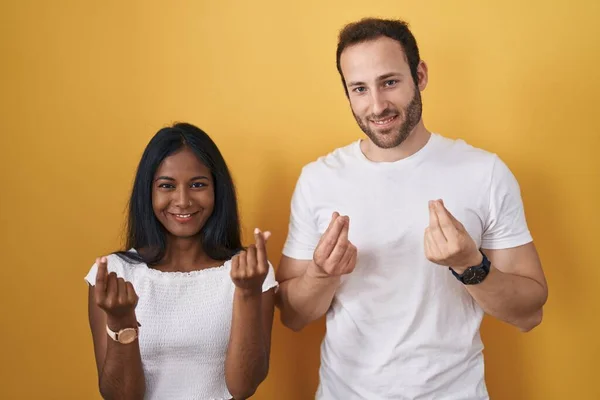 Interracial Couple Standing Yellow Background Doing Money Gesture Hands Asking — 图库照片
