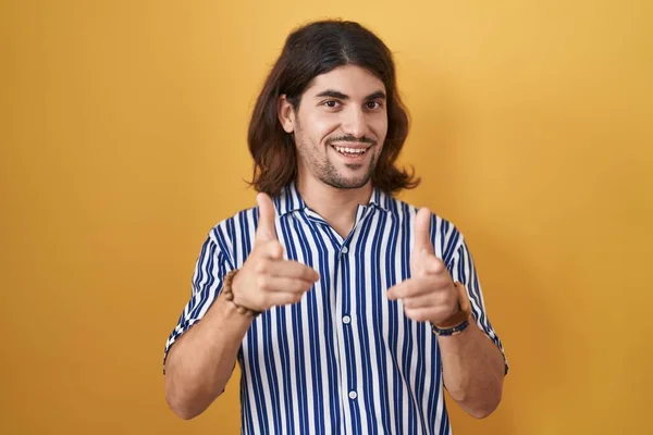 Hispanic Man Long Hair Standing Yellow Background Pointing Fingers Camera — ストック写真