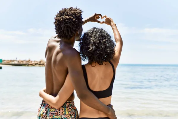 Junges Gemischtrassiges Touristenpaar Badebekleidung Das Strand Ein Herz Mit Händen — Stockfoto