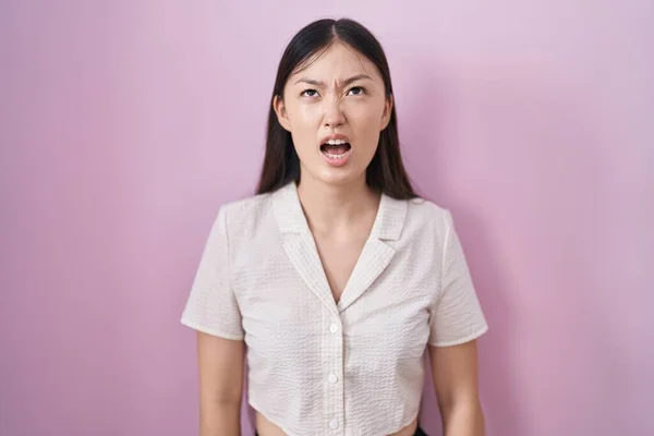 Chińska Młoda Kobieta Stojąca Nad Różowym Tle Wściekła Wściekła Krzycząc — Zdjęcie stockowe