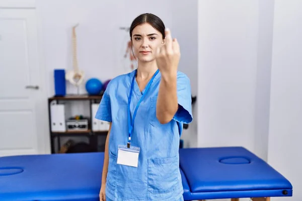 Young Hispanic Woman Wearing Physiotherapist Uniform Standing Clinic Showing Middle — Foto Stock