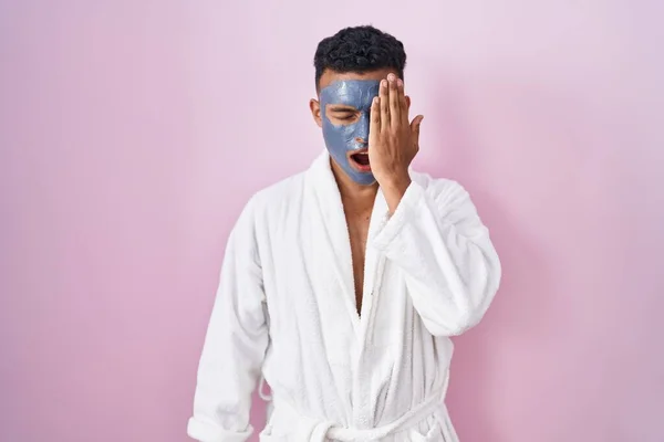 Young Hispanic Man Wearing Beauty Face Mask Bath Robe Yawning — Stockfoto