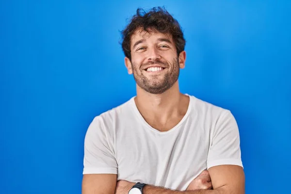 Jovem Hispânico Sobre Fundo Azul Rosto Feliz Sorrindo Com Braços — Fotografia de Stock