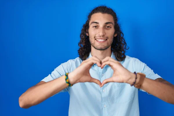 Ung Latinamerikansk Man Står Över Blå Bakgrund Leende Kärlek Gör — Stockfoto