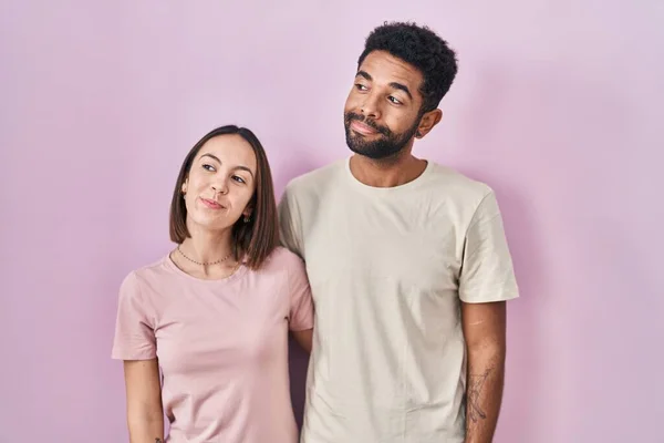 Young Hispanic Couple Together Pink Background Smiling Looking Side Staring — Stockfoto