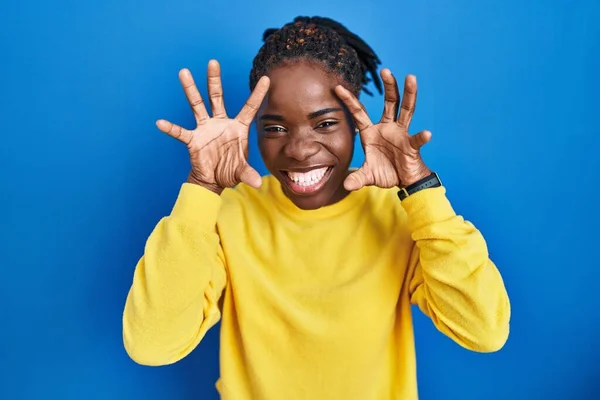 Beautiful Black Woman Standing Blue Background Smiling Funny Doing Claw — Stockfoto