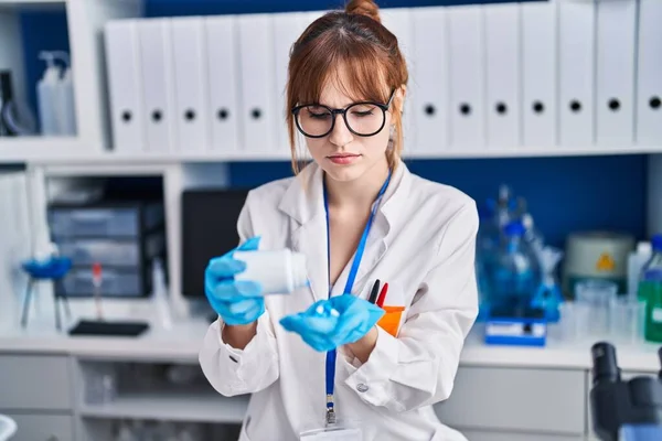 研究室で丸薬を持っている若い女性科学者 — ストック写真