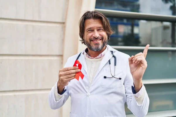 Guapo Médico Mediana Edad Hombre Sosteniendo Apoyo Cinta Roja Sonriendo — Foto de Stock