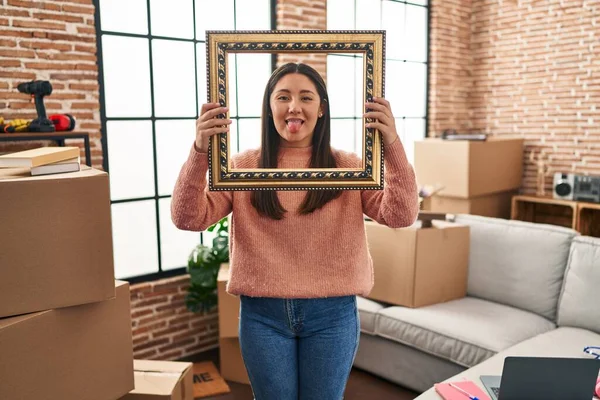 Young Latin Woman Moving New Home Holding Empty Frame Sticking — Stockfoto